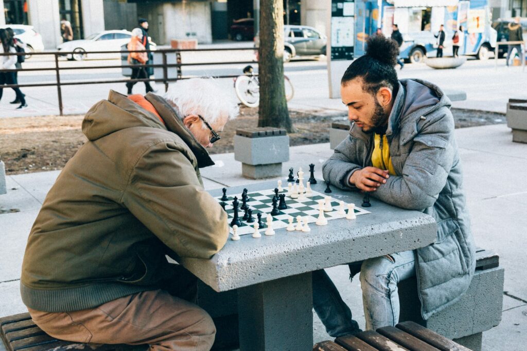 Two men playing chess in a park